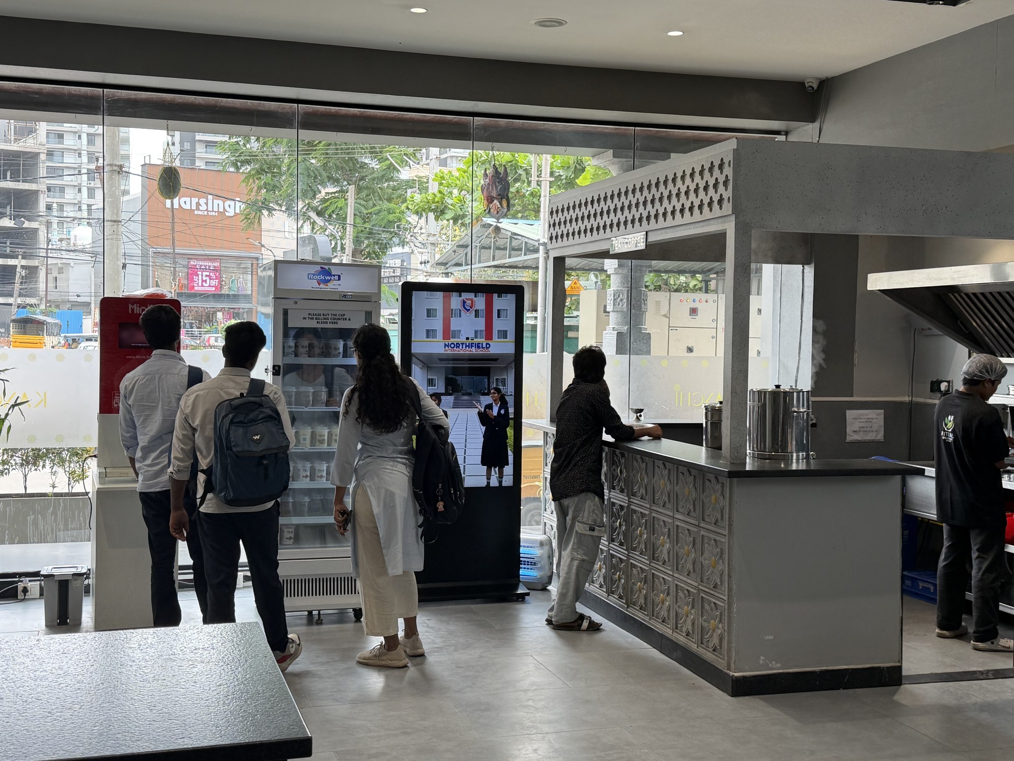 Northfield International School ad on KMEDIA standee inside a modern cafe