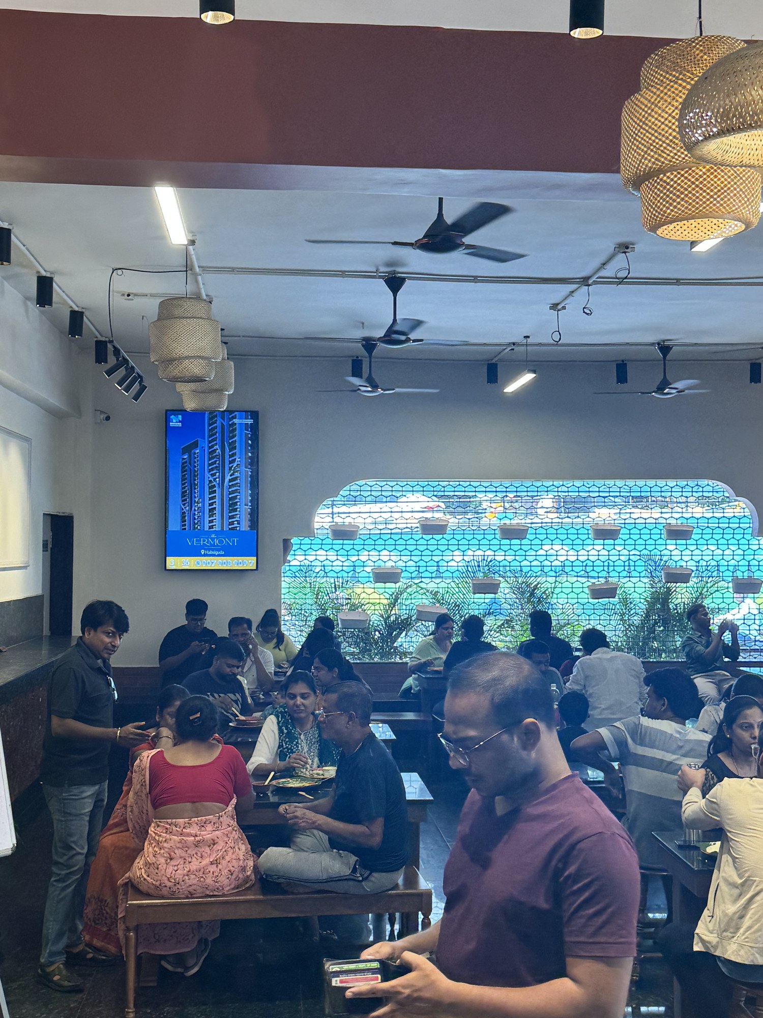 The Vermont real estate ad on KMEDIA screen in a crowded Hyderabad restaurant